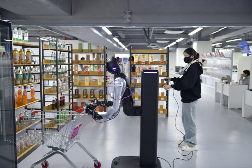 An operator trains a robot to display goods. Photo: VCG
